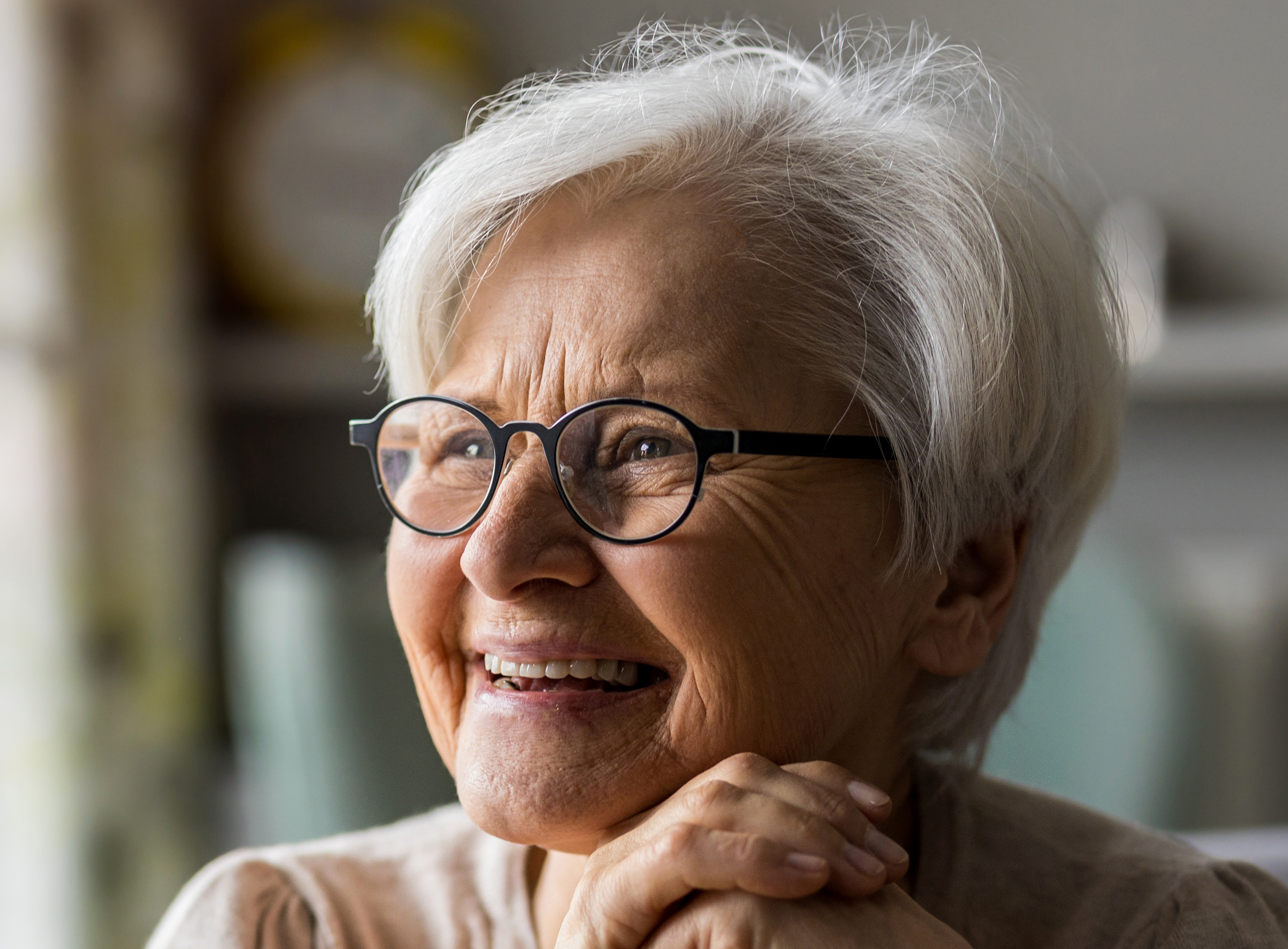 An older female wearing glasses and smiling.